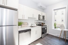 Winnipeg apartment for rent - a small kitchen with white cabinets and stainless steel appliances