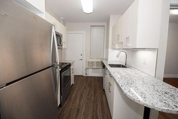 Winnipeg apartment for rent - A kitchen with a stainless steel refrigerator and a granite countertop.