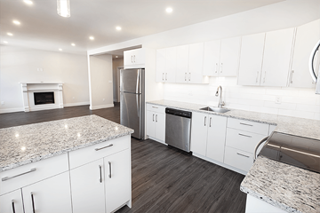 Winnipeg apartment for rent - a renovated kitchen with white cabinets and stainless steel appliances