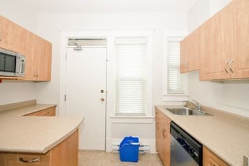 Winnipeg apartment for rent - a kitchen with wooden cabinets and a sink and a refrigerator