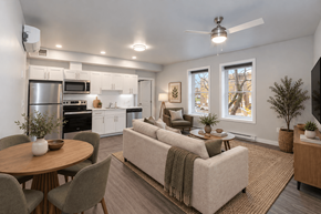 Winnipeg apartment for rent - A modern living room with a couch, chairs, and a dining table.