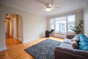 Winnipeg apartment for rent - A living room with a grey couch and a black rug.
