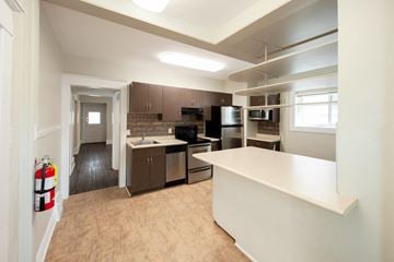 Winnipeg triplex for rent - A kitchen with a white counter and brown cabinets.
