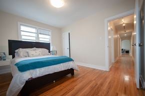Winnipeg apartment for rent - A bedroom with a bed and a wooden floor.