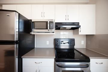 Winnipeg apartment for rent - a kitchen with stainless steel appliances and white cabinets