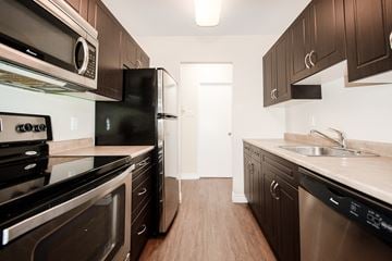 Winnipeg apartment for rent - a kitchen with stainless steel appliances and dark wood cabinets
