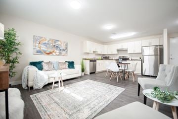 Winnipeg apartment for rent - a living room with a couch and a kitchen with a table and chairs