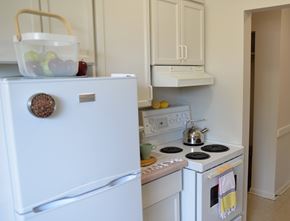 Winnipeg apartment for rent - White fridge and stove setup with compact countertops in 359 Edison’s kitchen.