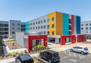 San Ysidro apartment for rent - A colorful building with a parking lot in front.
