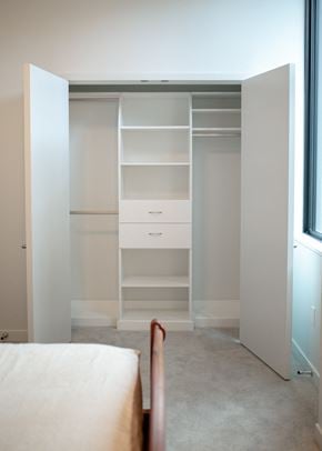 Portland apartment for rent - a bedroom with a closet with shelves and a bed and a window