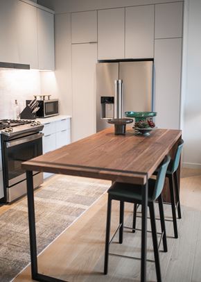 Portland apartment for rent - a kitchen with a wooden table and white cabinets