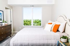 Minnetonka apartment for rent - Inviting apartment bedroom with expansive nature views, featuring spacious walk-in closets and the comfort of central heating and air conditioning.