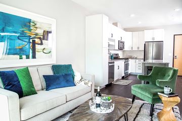 Minnetonka apartment for rent - A modern living room with a white couch and a green armchair.