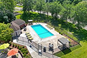 Plymouth townhouse for rent - a backyard with a swimming pool and patio with chairs and umbrellas