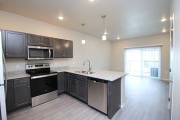 Sioux Falls apartment for rent - A kitchen with dark brown cabinets and stainless steel appliances.