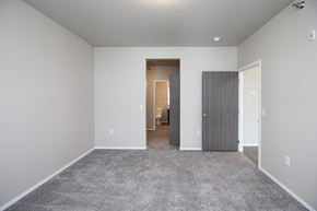 Sioux Falls apartment for rent - A spacious room with a carpeted floor and two doors.