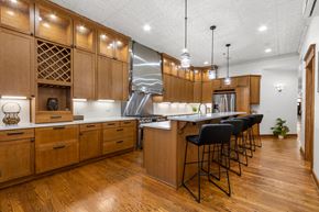Sioux Falls apartment for rent - A kitchen with wooden cabinets and black bar stools.