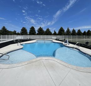 Sioux Falls apartment for rent - A large outdoor swimming pool surrounded by a fence.