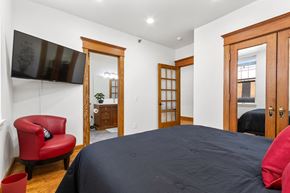 Sioux Falls apartment for rent - A bedroom with a large bed and a red chair.