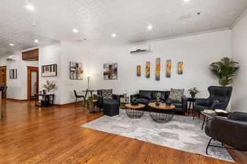 Sioux Falls apartment for rent - A living room with a black couch and a grey rug.