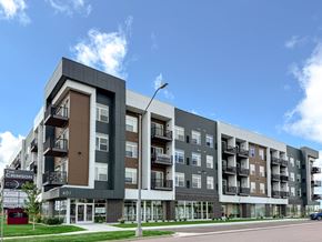 Sioux Falls apartment for rent - The Crimson apartment building is a modern, multi-story structure with balconies and large windows.