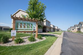 Sioux Falls townhouse for rent - a sign for the west 27th street commons in front of a row of houses