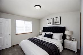 Sioux Falls townhouse for rent - A bedroom with a large bed and two nightstands.