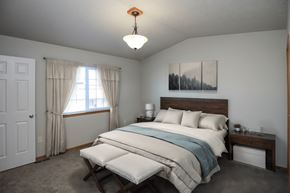 Sioux Falls townhouse for rent - A bedroom with a bed, nightstand, and window.