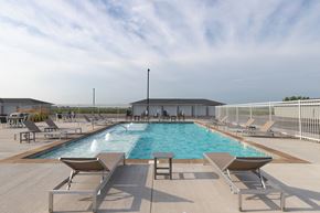 Sioux Falls apartment for rent - A large outdoor swimming pool surrounded by sun loungers.