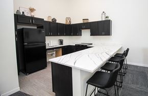 Sioux Falls apartment for rent - A kitchen with black cabinets and a white island.