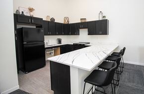 Sioux Falls apartment for rent - A kitchen with black cabinets and a white island.