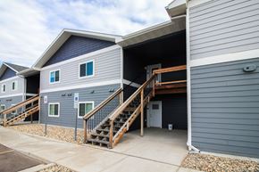 Sioux Falls apartment for rent - A grey building with a blue sky in the background.