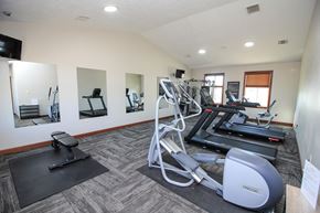 Sioux Falls apartment for rent - A gym with a treadmill, a stationary bike, a rowing machine, and a bench.