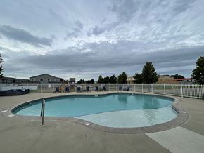 Sioux Falls apartment for rent - A large outdoor swimming pool with a metal fence around it.