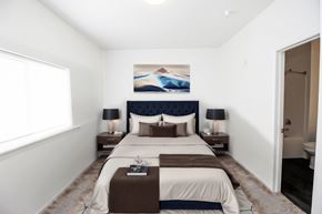 Sioux Falls apartment for rent - A bedroom with a large bed and a painting on the wall.