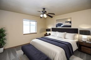 Sioux Falls townhouse for rent - A bedroom with a large bed and a ceiling fan.