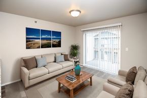 Sioux Falls apartment for rent - A living room with a couch, a coffee table, and a large window with a view of the outside.