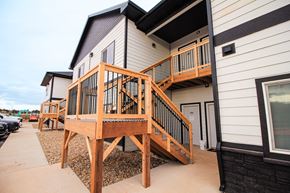 Rapid City apartment for rent - A wooden deck with a railing is in front of a house.