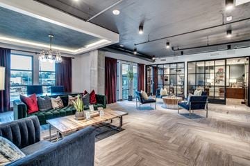 Dallas apartment for rent - A modern living room with a dark grey sofa and a wooden coffee table.