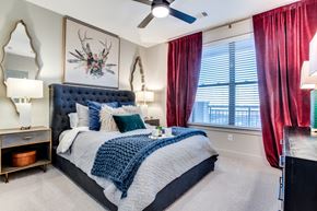 Dallas apartment for rent - A bedroom with a large bed and a deer head on the wall.