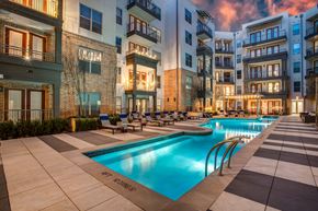 Dallas apartment for rent - A large swimming pool in the middle of a courtyard surrounded by buildings.