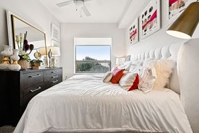 Houston apartment for rent - A bedroom with a large bed, a dresser, and a mirror.