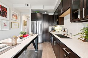 Houston apartment for rent - A modern kitchen with dark brown cabinets and a white countertop.