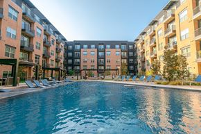 Dallas apartment for rent - A swimming pool in front of apartment buildings.