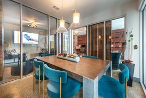 Fort Worth apartment for rent - A modern dining room with a wooden table and blue chairs.