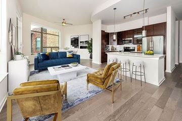 Houston apartment for rent - a living room and kitchen with a blue couch and a white table
