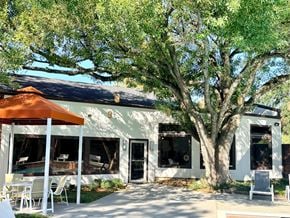 Houston apartment for rent - A white building with a brown umbrella in front of it.