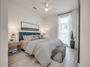 Houston apartment for rent - a bedroom with a bed and a ceiling fan