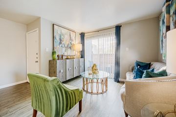 Houston apartment for rent - A living room with a green chair and a white couch.