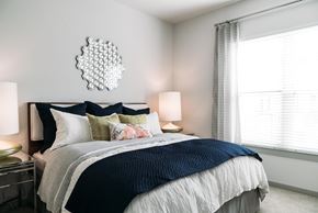 San Antonio apartment for rent - A bedroom with a large bed and a mirror on the wall.